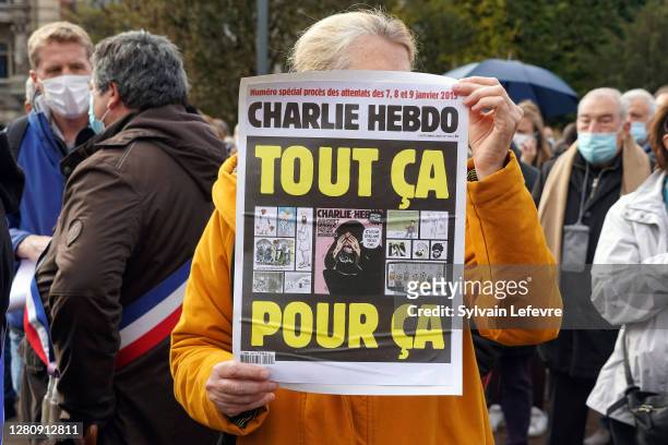 Woman holds a sign where it says "Charlie Hebdo. All for this" during the rally in memory of Samuel Paty, the French teacher who was beheaded on the...