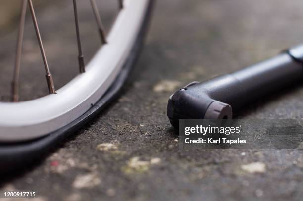 flat bicycle tire with bicycle pump outdoor - flat tire fotografías e imágenes de stock