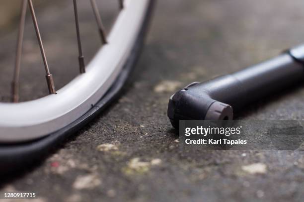flat bicycle tire with bicycle pump outdoor - bicycle tire stockfoto's en -beelden