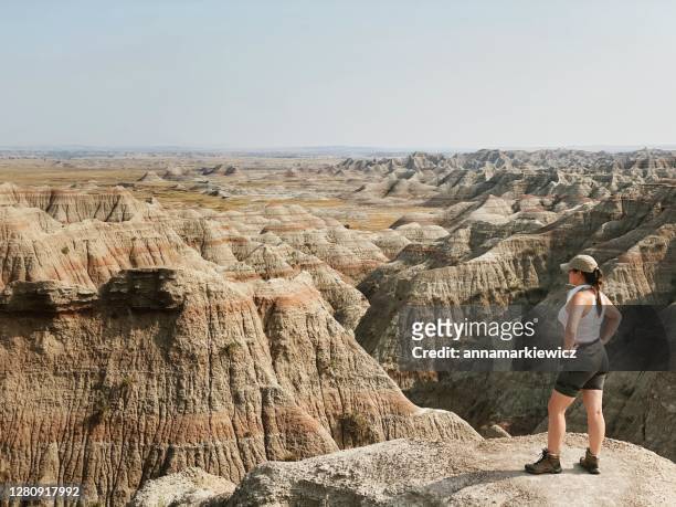 female hiker looking at view, badlands national park, south dakota, usa - badlands national park stock pictures, royalty-free photos & images