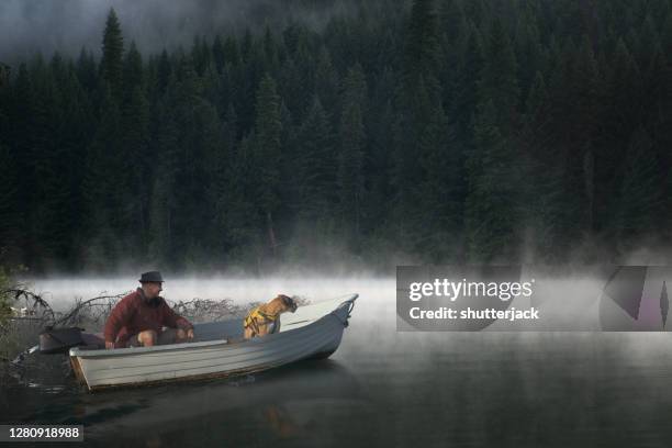 man sitting in a boat with his dog, usa - american bulldog stock pictures, royalty-free photos & images