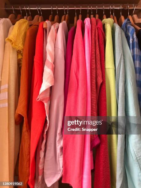 rainbow coloured tops hanging in a wardrobe - hanging blouse stock pictures, royalty-free photos & images