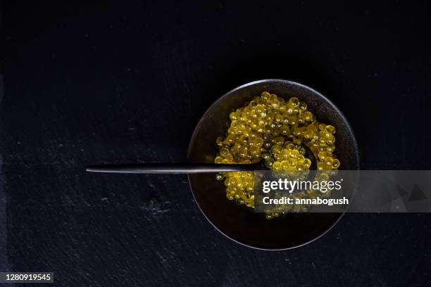 overhead view of a bowl of yellow trout caviar - kaviar stock-fotos und bilder