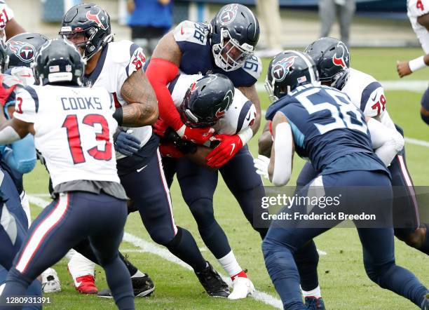 Jeffery Simmons of the Tennessee Titans wraps up running back David Johnson of the Houston Texans in the first quarter at Nissan Stadium on October...