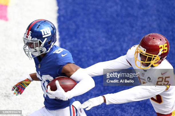 Darius Slayton of the New York Giants scores a touchdown in front of Fabian Moreau of the Washington Football Team in the first quarter of their NFL...