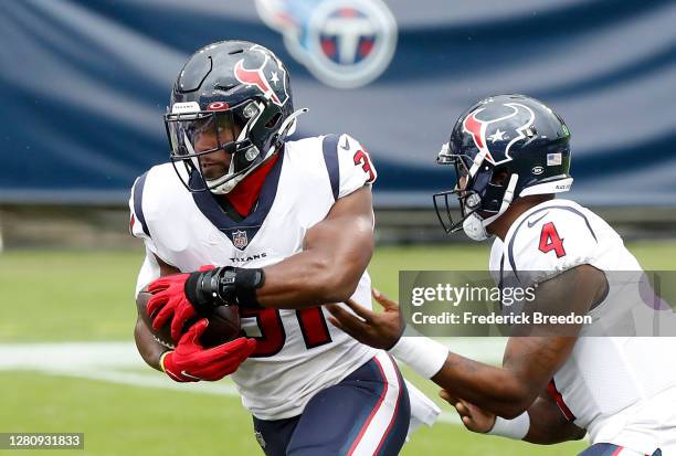 Running back David Johnson of the Houston Texans takes the hand off from quarterback Deshaun Watson in the first quarter against the Tennessee Titans...