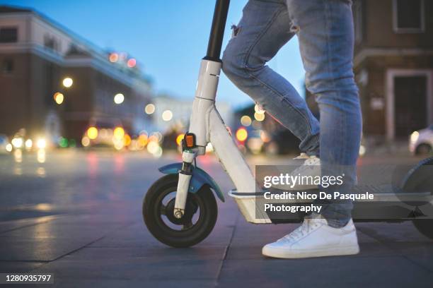 man using electric push scooter - patinete a motor fotografías e imágenes de stock