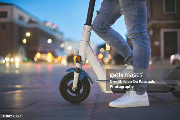 man using electric push scooter - push scooter stock pictures, royalty-free photos & images
