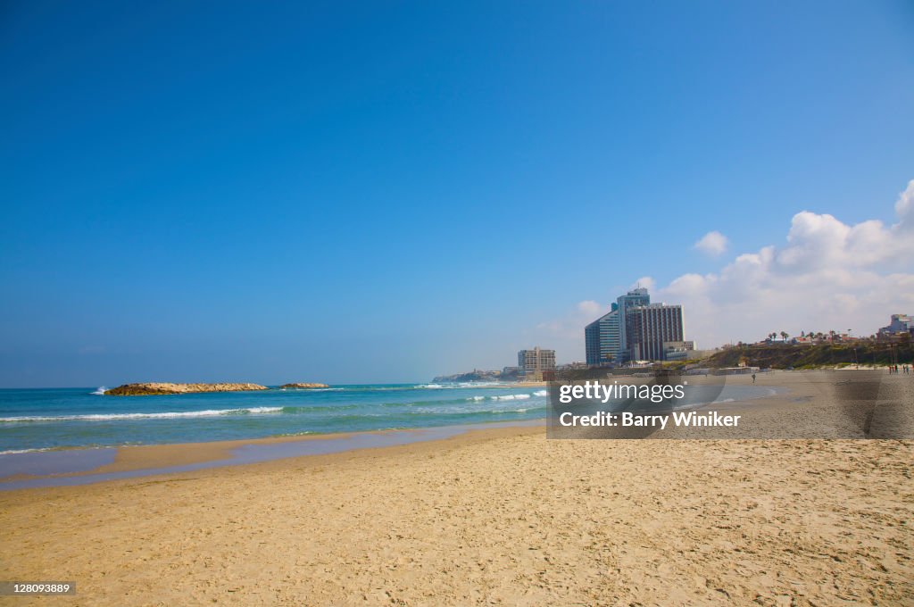Sand beach, sky and hotel towers of Herzliya, Israel