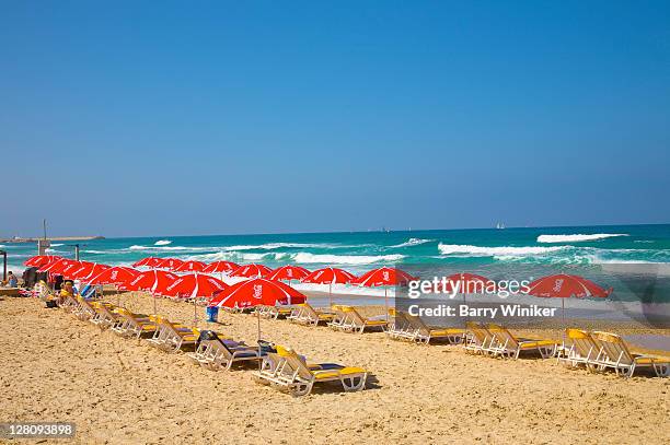 umbrellas, beach chairs, sand, surf, beach and sky on hasharon beach on mediterranean sea in herzliya, israel - tel aviv stock-fotos und bilder