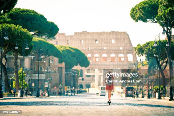 tourist riding electric scooter in rome. italy - coliseo romano fotografías e imágenes de stock