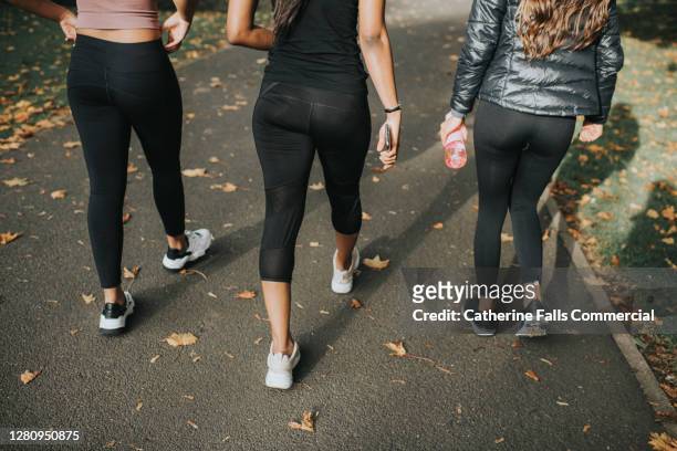 woman in sportswear walk on a path - legging stockfoto's en -beelden