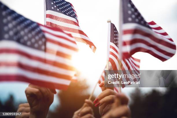 multitud celebrando con la bandera nacional de estados unidos - bandera estadounidense fotografías e imágenes de stock