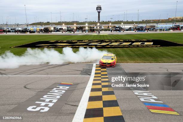 Joey Logano, driver of the Shell Pennzoil Ford, celebrates with a burnout after winning the NASCAR Cup Series Hollywood Casino 400 at Kansas Speedway...