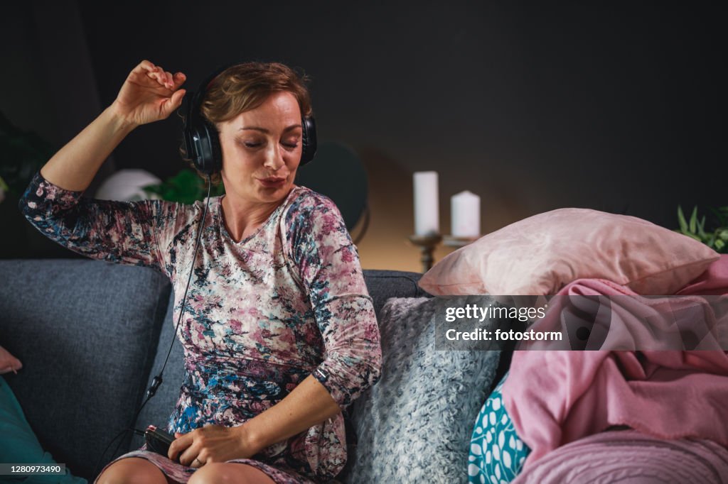 Donna matura che si gode la discoteca silenziosa a casa durante la quarantena