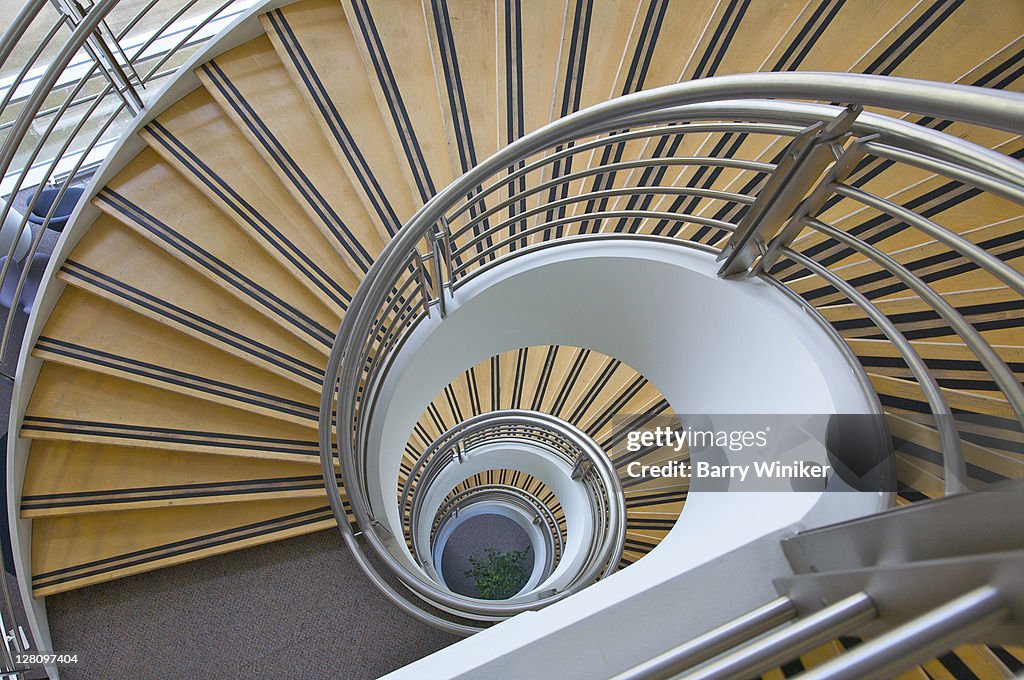 Multi-floor geometric spiral staircase looking downward