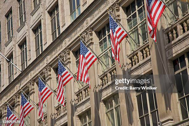american flags hanging outside saks fifth avenue, new york - saks stock-fotos und bilder