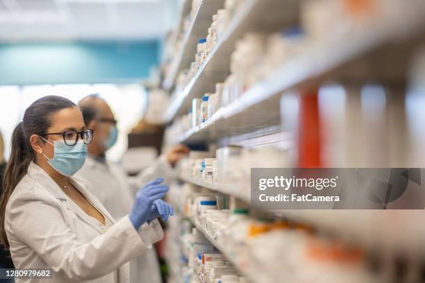 masked pharmacist - pharmaceutical industry stock pictures, royalty-free photos & images