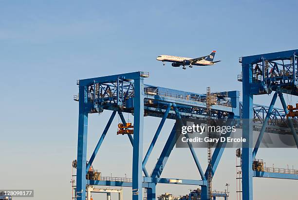 container unloading gantry with jet flying over, south boston, ma - south boston massachusetts photos et images de collection