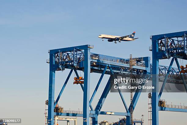 container unloading gantry with jet flying over, south boston, ma - south boston - massachusetts foto e immagini stock