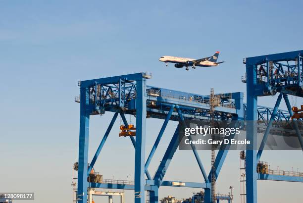 container unloading gantry with jet flying over, south boston, ma - south boston massachusetts bildbanksfoton och bilder