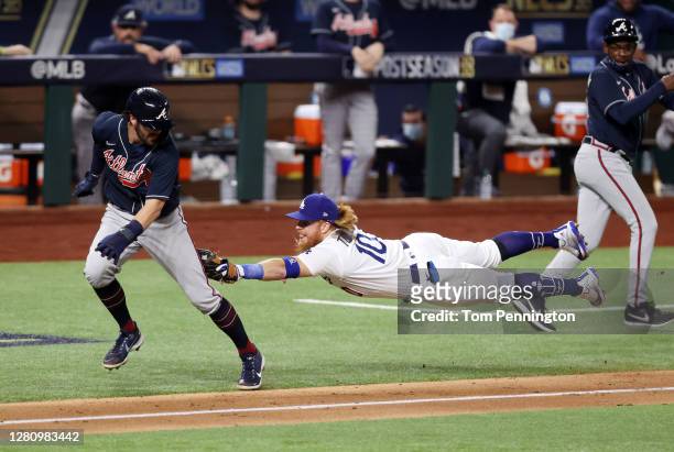 Dansby Swanson of the Atlanta Braves is tagged out by Justin Turner of the Los Angeles Dodgers in a rundown between third base and home plate during...