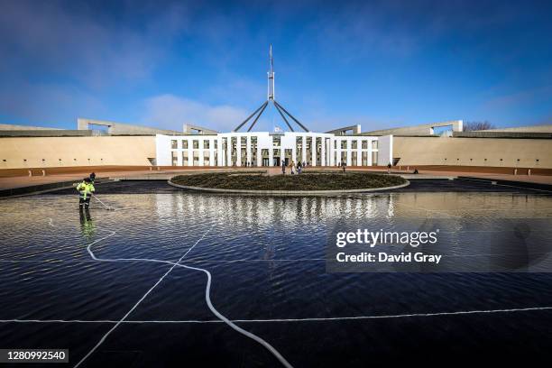 Workman cleans the pond located at the front of Parliament House on July 9, 2020 in Canberra, Australia.
