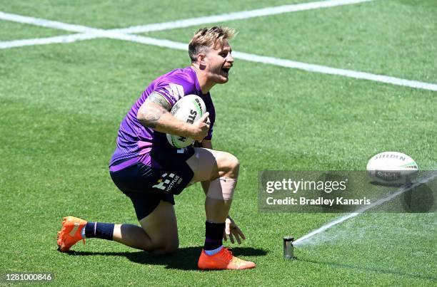 Cameron Munster has a laugh with his team mates as he turns the water sprinkler on Coach Craig Bellamy during a Melbourne Storm NRL training session...