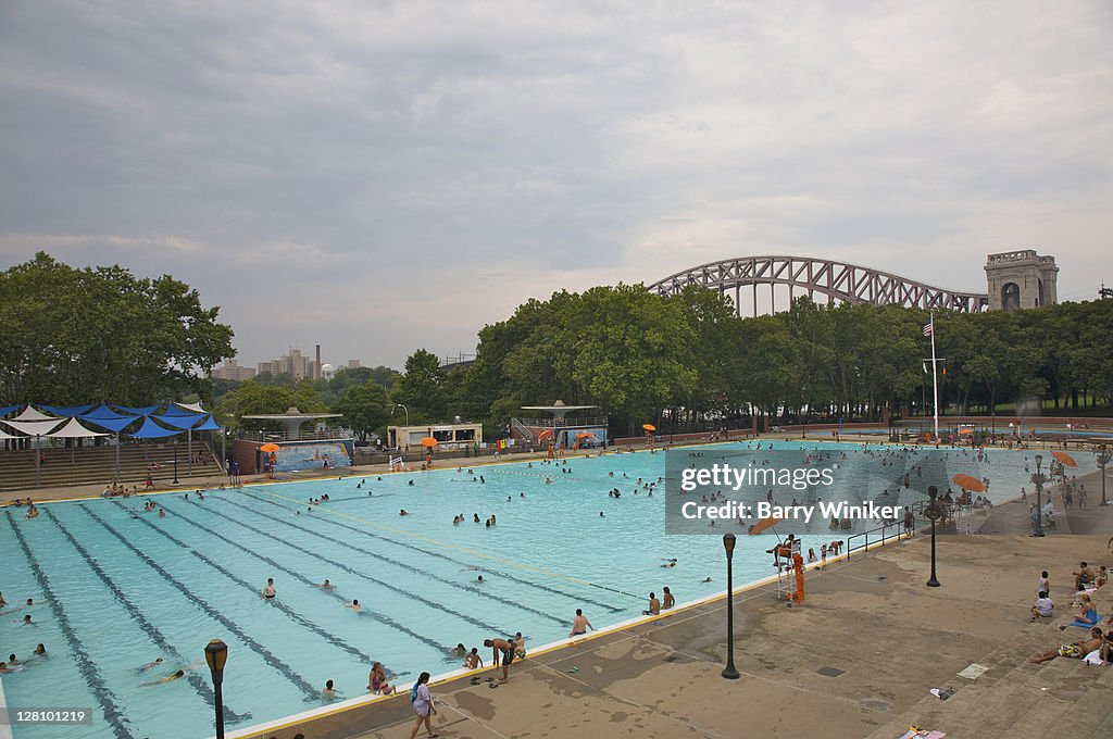 People in Astoria Pool in Astoria Park beneath Hell Gate Bridge, Astoria, Queens, NY