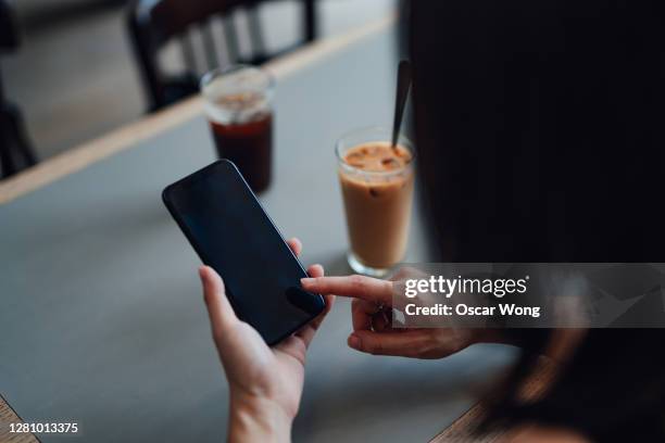 close-up of young woman using smart phone at cafe - close up hand smart phone stock pictures, royalty-free photos & images