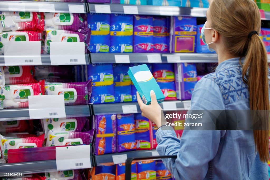 Giovane donna che compra tamponi in mezzo all'epidemia di covid-19