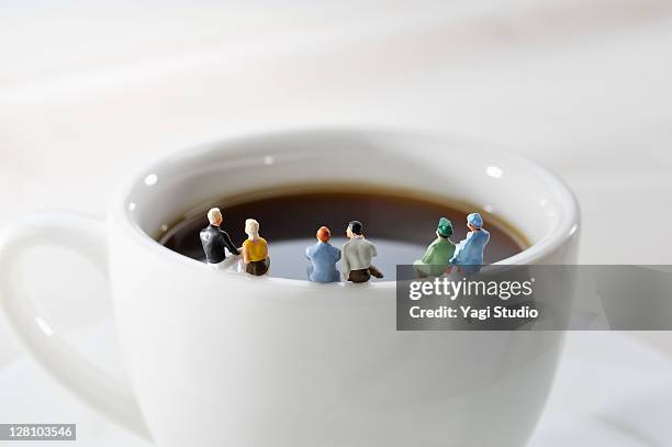 miniature doll sat chatting on a cup - figurine bildbanksfoton och bilder