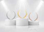 Winner pedestal with laurel. White cylinder podiums under spotlights realistic mockup. Gold silver bronze leaf round wreath on stages, first second third place award ceremony vector concept