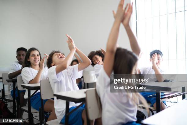 elementary students celebrating in the classroom at school - private school uniform stock pictures, royalty-free photos & images