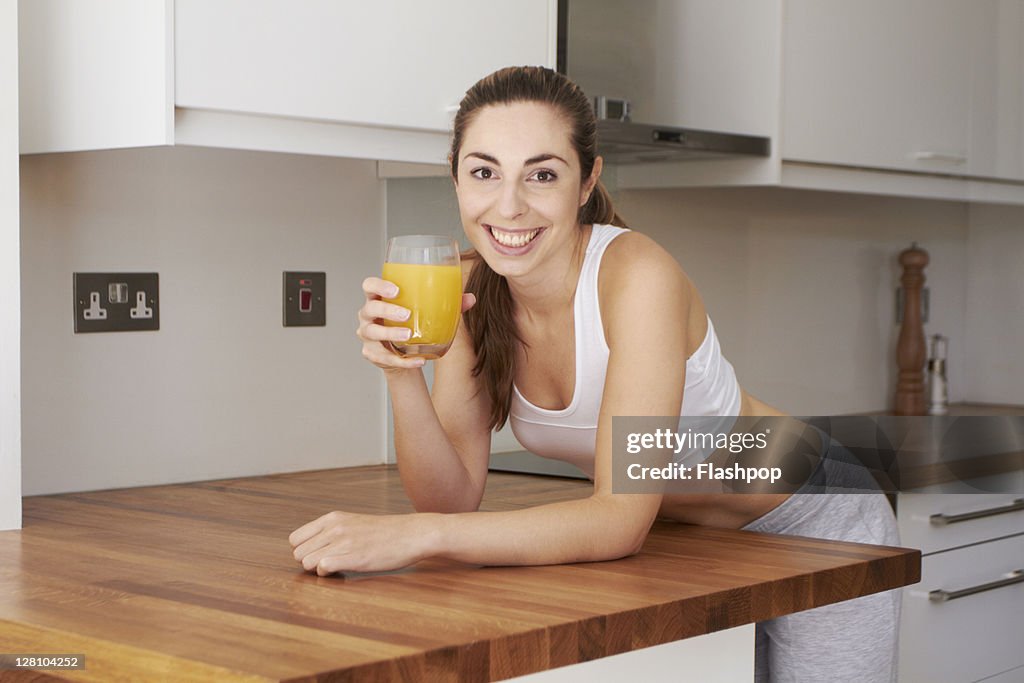 Woman holding orange juice after exercising