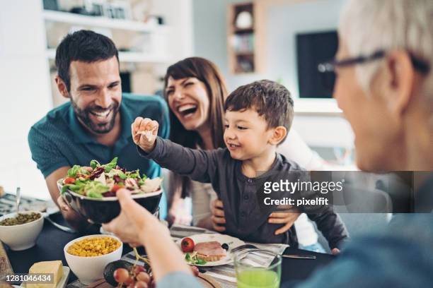 mehrgenerationenfamilie beim gemeinsamen mittagessen - speisen und getränke stock-fotos und bilder