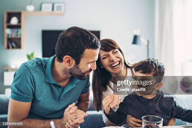 father talking to his little son during a family dinner - toddler eating sandwich stock pictures, royalty-free photos & images