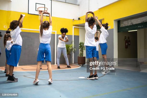 physical activity teacher stretching arms with students at school - physical education stock pictures, royalty-free photos & images