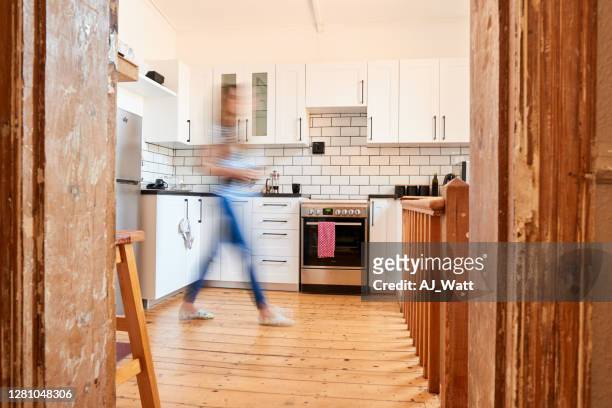 woman in blurred motion working in her kitchen - blurred motion home stock pictures, royalty-free photos & images