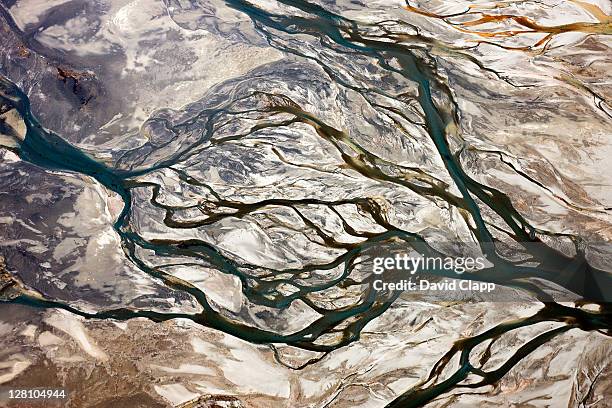 aerial of braided, glacial river channels flowing into other where godley river joins lake tekapo, southern alps, new zealand - moräne stock-fotos und bilder