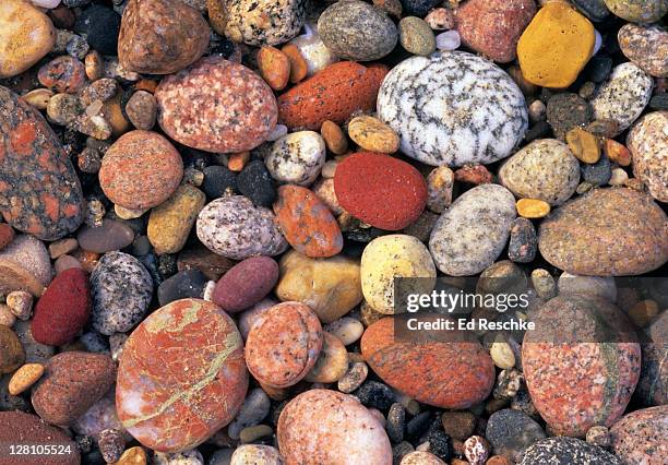 multicolored rocks. lake superior shoreline, pictured rocks national lakeshore, michigan. twelve mile beach. stones include polished granite and quartz rounded like eggs. - mile high stock-fotos und bilder