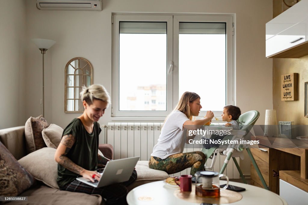 Family life. Lesbian couple with baby at home.
