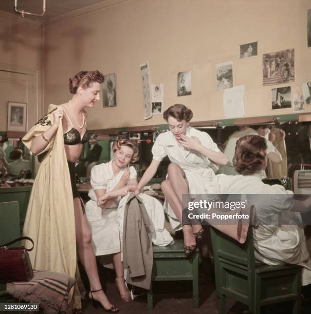 Four female fashion models employed by French fashion designer Jeanne Lanvin, relax in a dressing room between fittings at the Lanvin haute couture...