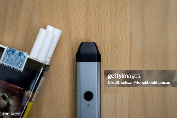 e-cigarette closeup with cigarette - electronic cigarette ストックフォトと画像