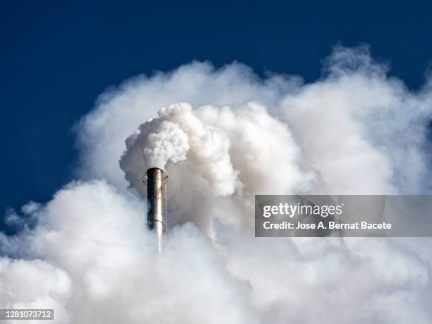 industrial factory chimney emitting smoke and gas pollution into the atmosphere. - gas di scarico foto e immagini stock