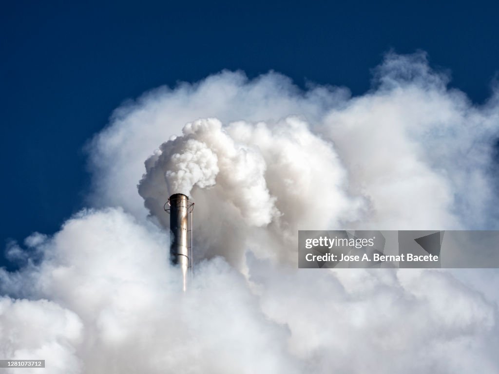 Industrial factory chimney emitting smoke and gas pollution into the atmosphere.