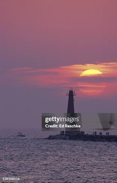 muskegon south pier light and a lake michigan sunset. muskegon, michigan - northern michigan stock pictures, royalty-free photos & images