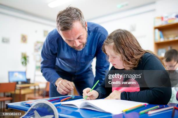 teenage girl with down syndrome drawing at class - special education stock pictures, royalty-free photos & images