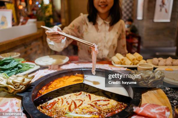 an asian chinese woman boiling a pork slice with hot pot soup - hot pots stock pictures, royalty-free photos & images