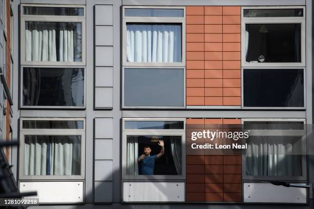 Students gesture from the windows of the apartments that have been deemed unsafe on October 19, 2020 in Brentford, England. Paragon is a development...